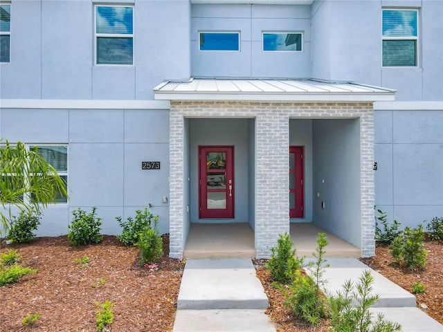 property entrance featuring metal roof, brick siding, and a standing seam roof