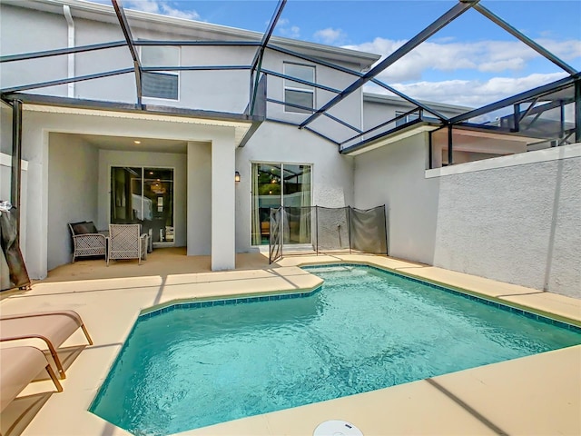 outdoor pool featuring glass enclosure and a patio