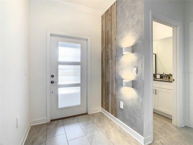 doorway with a wealth of natural light, crown molding, and baseboards