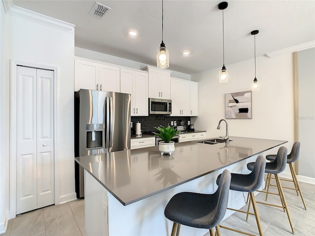 kitchen featuring stainless steel appliances, dark countertops, white cabinetry, and a sink