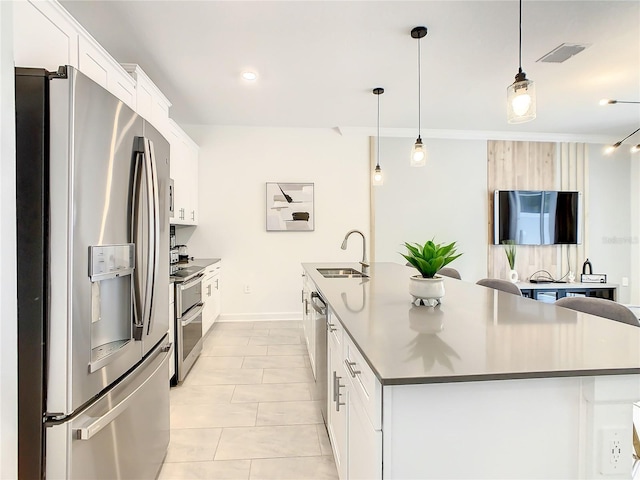 kitchen featuring a center island with sink, white cabinetry, stainless steel appliances, and a sink