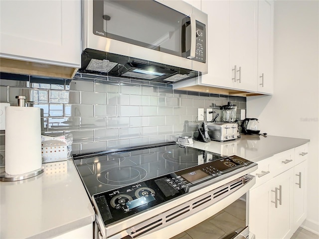 kitchen with appliances with stainless steel finishes, light countertops, white cabinets, and decorative backsplash