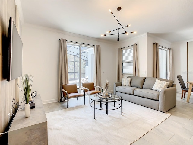 living room with ornamental molding, plenty of natural light, baseboards, and an inviting chandelier