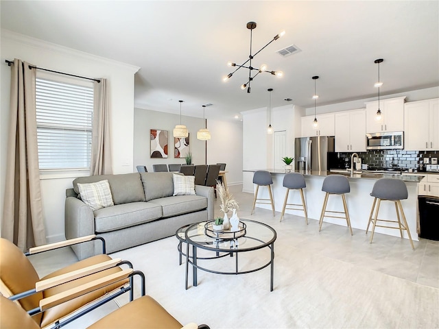 living room featuring visible vents, crown molding, and a notable chandelier