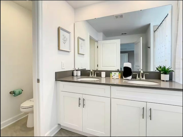 bathroom with toilet, double vanity, a sink, and visible vents