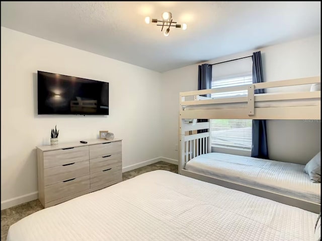 bedroom featuring baseboards and dark carpet