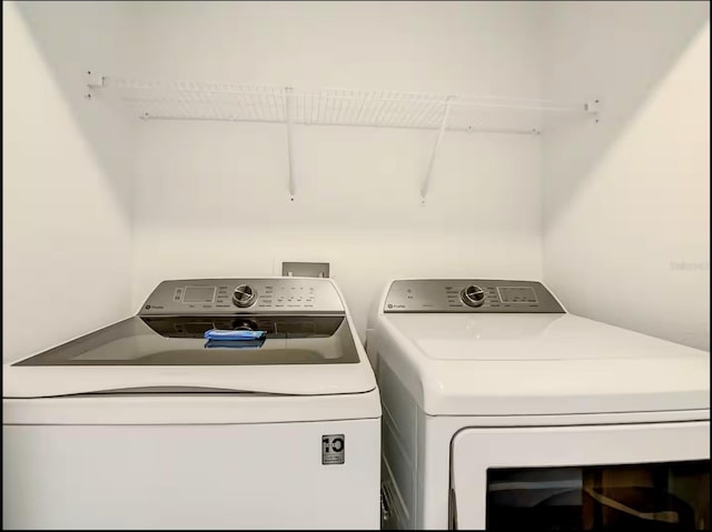 clothes washing area with washing machine and dryer and laundry area