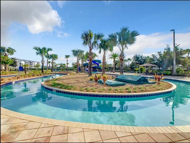 community pool with grilling area and a gazebo