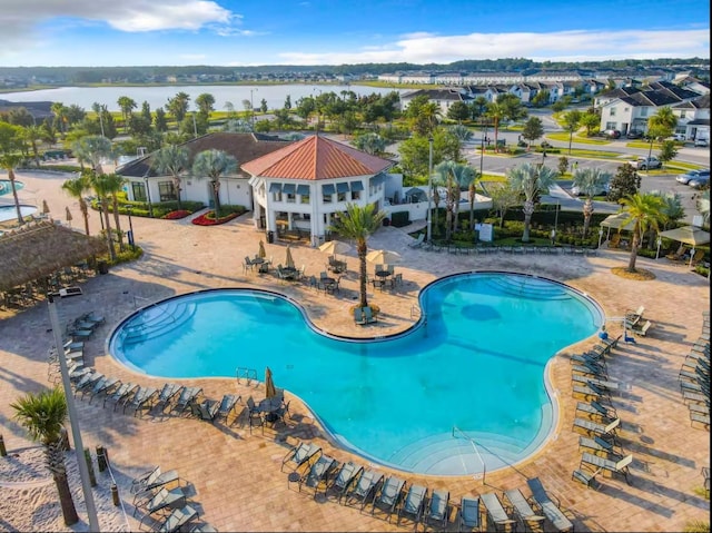 pool with a patio area and a water view