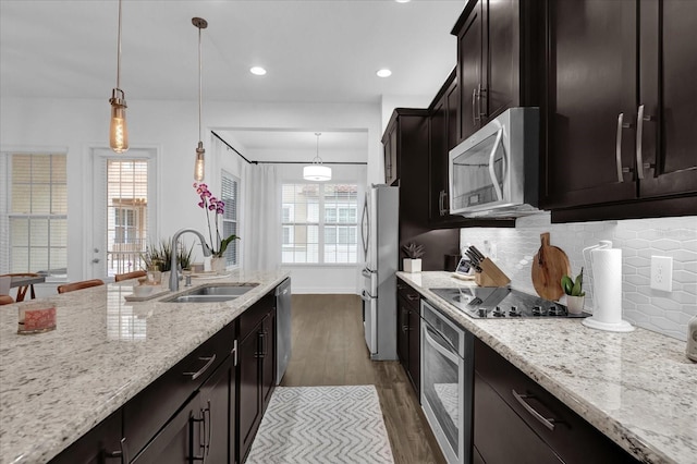 kitchen featuring appliances with stainless steel finishes, dark wood-style flooring, a sink, and a wealth of natural light