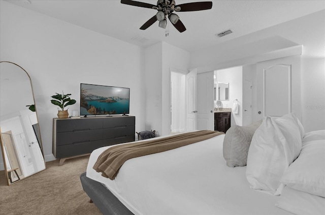 bedroom with a ceiling fan, visible vents, connected bathroom, and light carpet