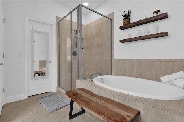 bathroom with a garden tub, a shower stall, and tile patterned floors