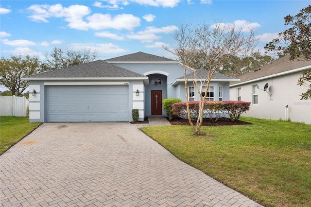 ranch-style house featuring a front lawn, decorative driveway, and stucco siding