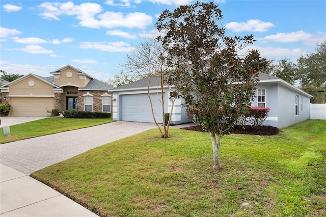 ranch-style house with a garage, stone siding, decorative driveway, stucco siding, and a front lawn