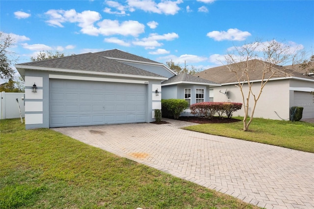 ranch-style house featuring decorative driveway, an attached garage, a front yard, and stucco siding