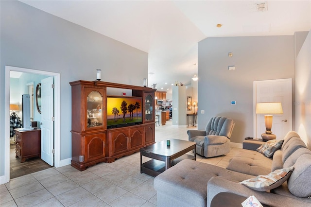 living room with lofted ceiling, light tile patterned floors, baseboards, and visible vents