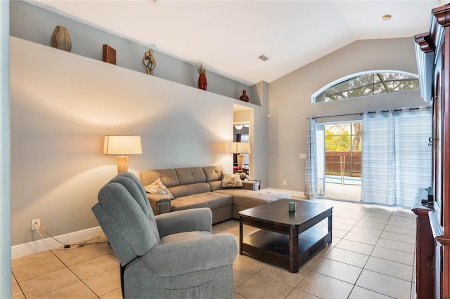 living area featuring light tile patterned floors, baseboards, visible vents, and vaulted ceiling