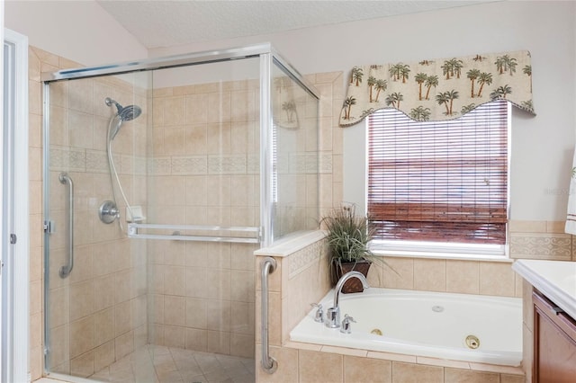 bathroom featuring a textured ceiling, a tub with jets, a stall shower, and vanity