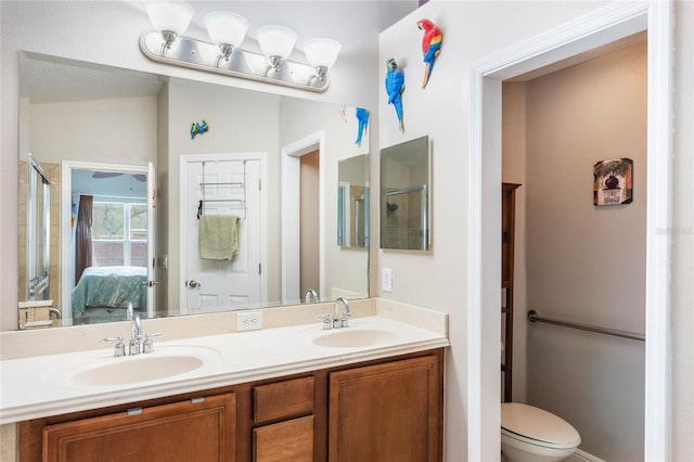 bathroom featuring double vanity, a sink, toilet, and ensuite bathroom