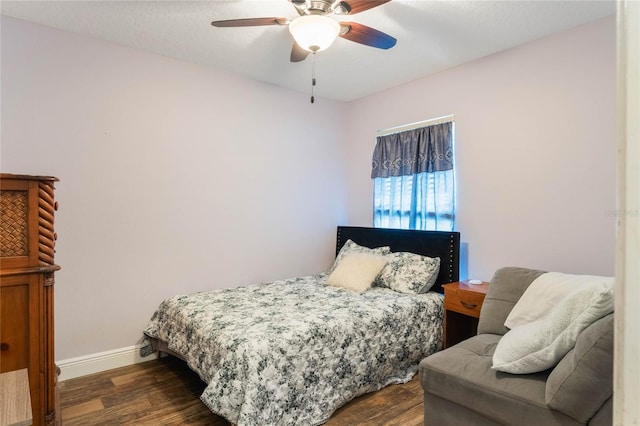 bedroom featuring ceiling fan, dark wood-style flooring, and baseboards