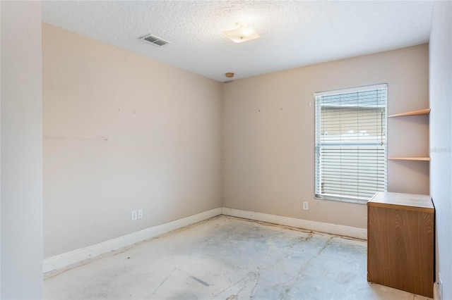 unfurnished room featuring a wealth of natural light, visible vents, baseboards, and a textured ceiling