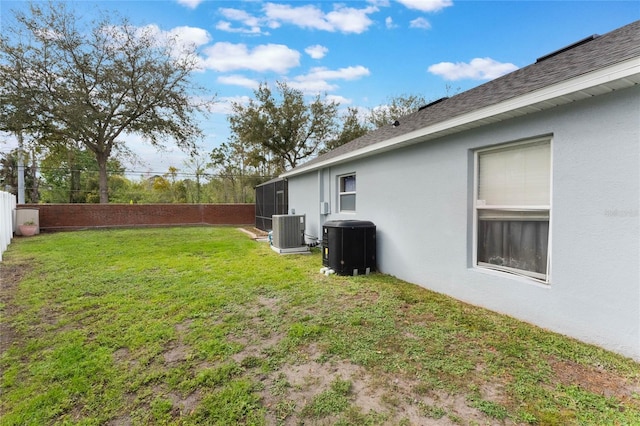 view of yard with a fenced backyard and central AC