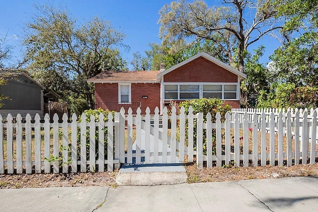 view of front facade featuring a fenced front yard and brick siding