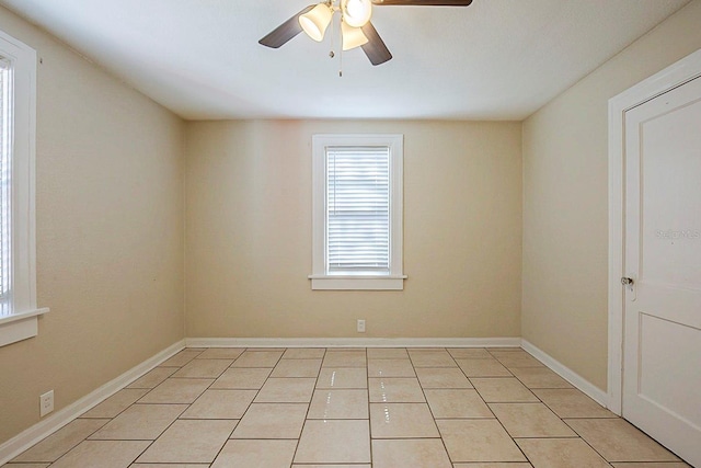 spare room featuring light tile patterned floors, baseboards, and a ceiling fan