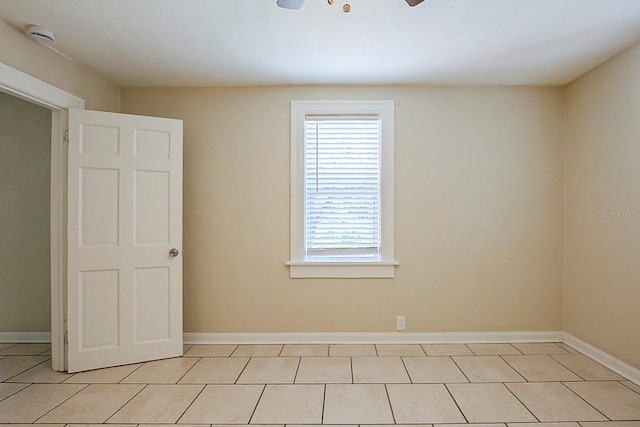 empty room with light tile patterned floors and baseboards