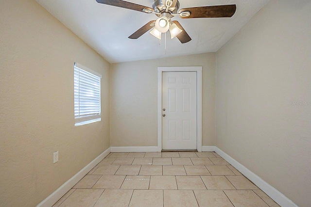 spare room featuring light tile patterned floors, a ceiling fan, baseboards, and vaulted ceiling