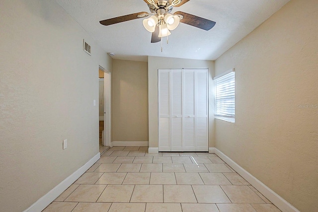 unfurnished bedroom featuring light tile patterned floors, baseboards, visible vents, and a closet