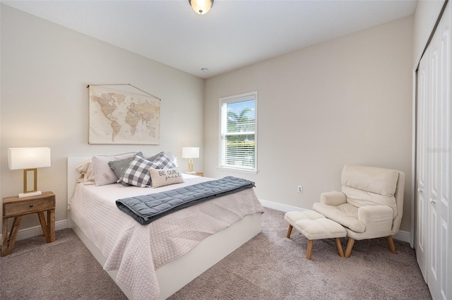 carpeted bedroom featuring a closet and baseboards