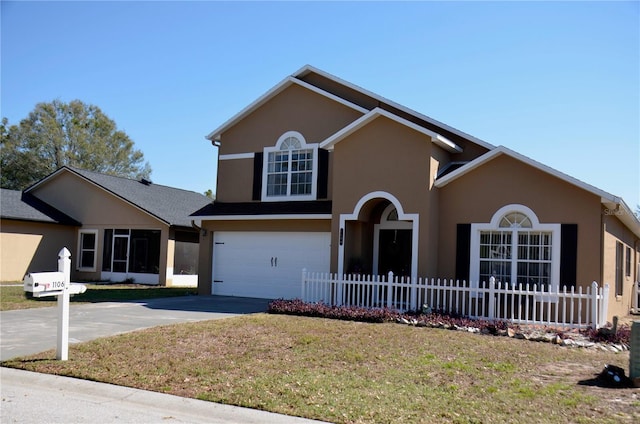 traditional home featuring stucco siding, an attached garage, fence, driveway, and a front lawn