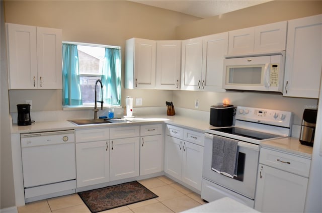 kitchen with light tile patterned floors, white appliances, a sink, white cabinetry, and light countertops