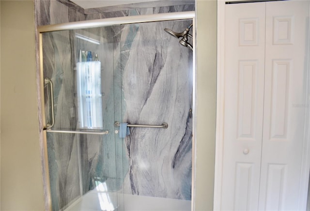 bathroom featuring a marble finish shower and a closet