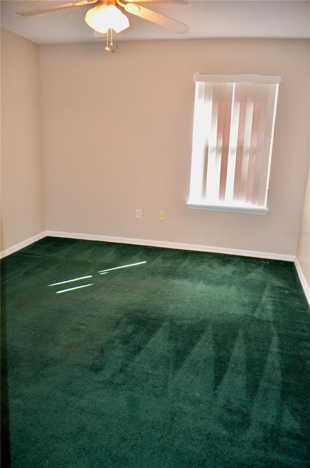 empty room featuring a ceiling fan, carpet, a textured ceiling, and baseboards