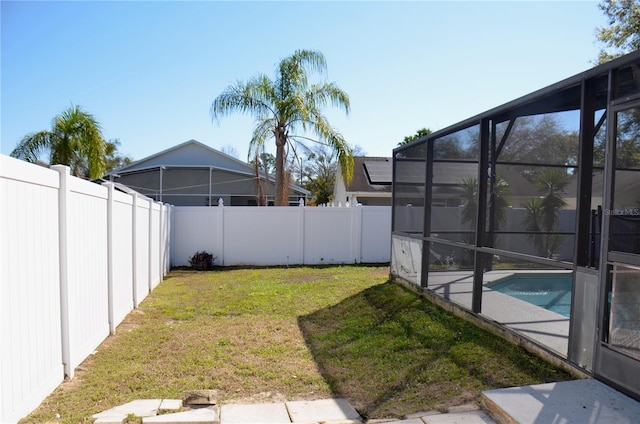 view of yard featuring glass enclosure, a fenced backyard, and a fenced in pool