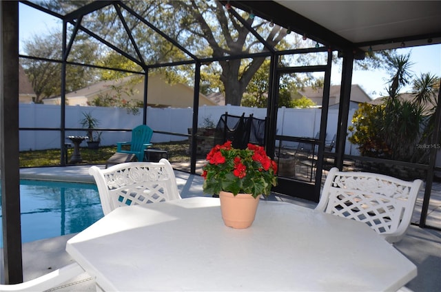 view of patio with outdoor dining area, a lanai, a fenced in pool, and fence