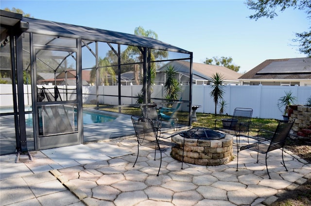 view of swimming pool with a lanai, a fenced backyard, a patio, and a fire pit