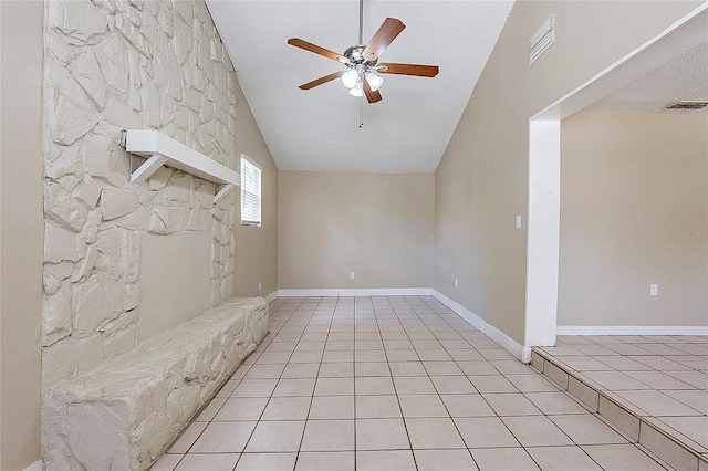 empty room with light tile patterned floors, visible vents, ceiling fan, vaulted ceiling, and a textured ceiling