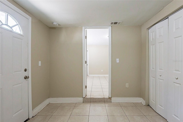 foyer entrance featuring light tile patterned flooring, visible vents, and baseboards