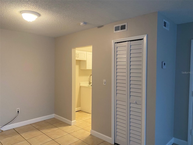 unfurnished bedroom featuring light tile patterned floors, visible vents, and baseboards