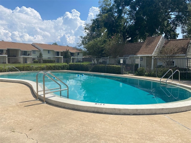 community pool with a residential view and fence