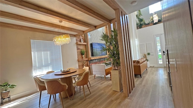 dining area featuring a chandelier, light wood-type flooring, beam ceiling, and baseboards