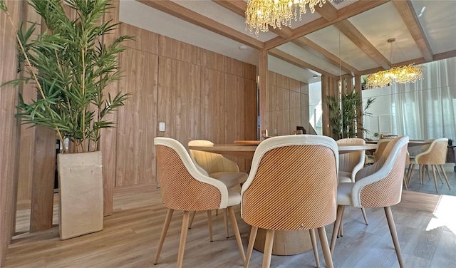 dining space featuring light wood-style flooring, bar, wood walls, beamed ceiling, and an inviting chandelier