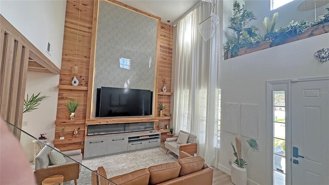 living room featuring light wood-style flooring and a towering ceiling