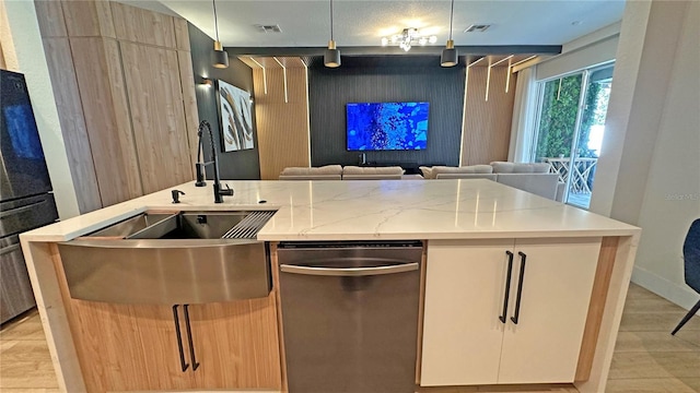 kitchen featuring a center island with sink, visible vents, stainless steel dishwasher, open floor plan, and a sink