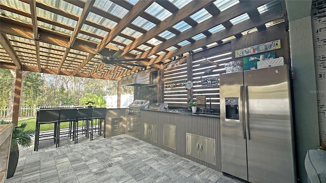 view of patio / terrace with grilling area, area for grilling, a ceiling fan, a bar, and a pergola