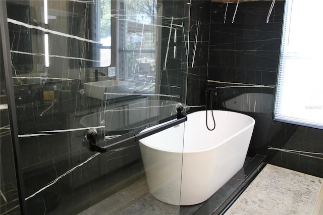 bathroom featuring a freestanding bath, tiled shower, and tile walls