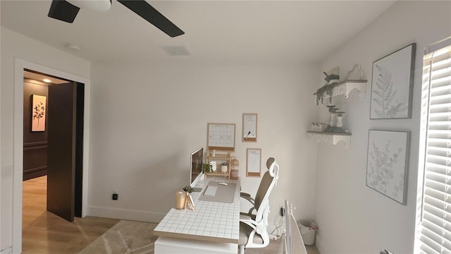 office with a ceiling fan, visible vents, light wood-style flooring, and baseboards